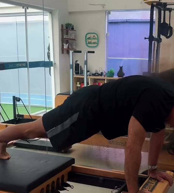 Aluno praticando Pilates em um aparelho do estúdio